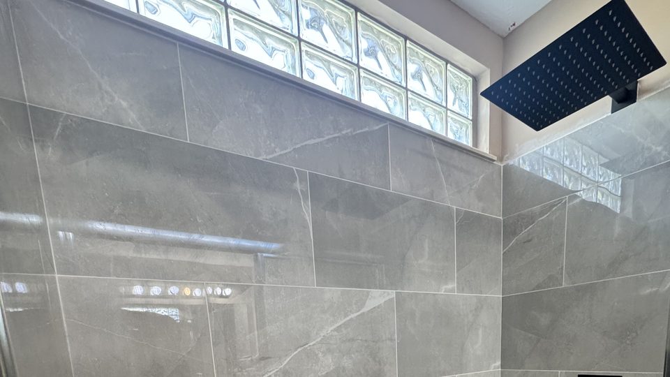 Finished tiled shower with black rain head, hand shower and white base, Mason, Ohio